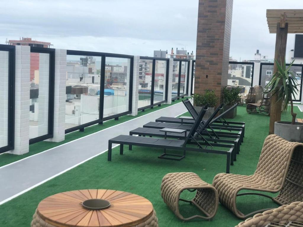 a patio with chairs and tables on a roof at Baltico302 in Capão da Canoa