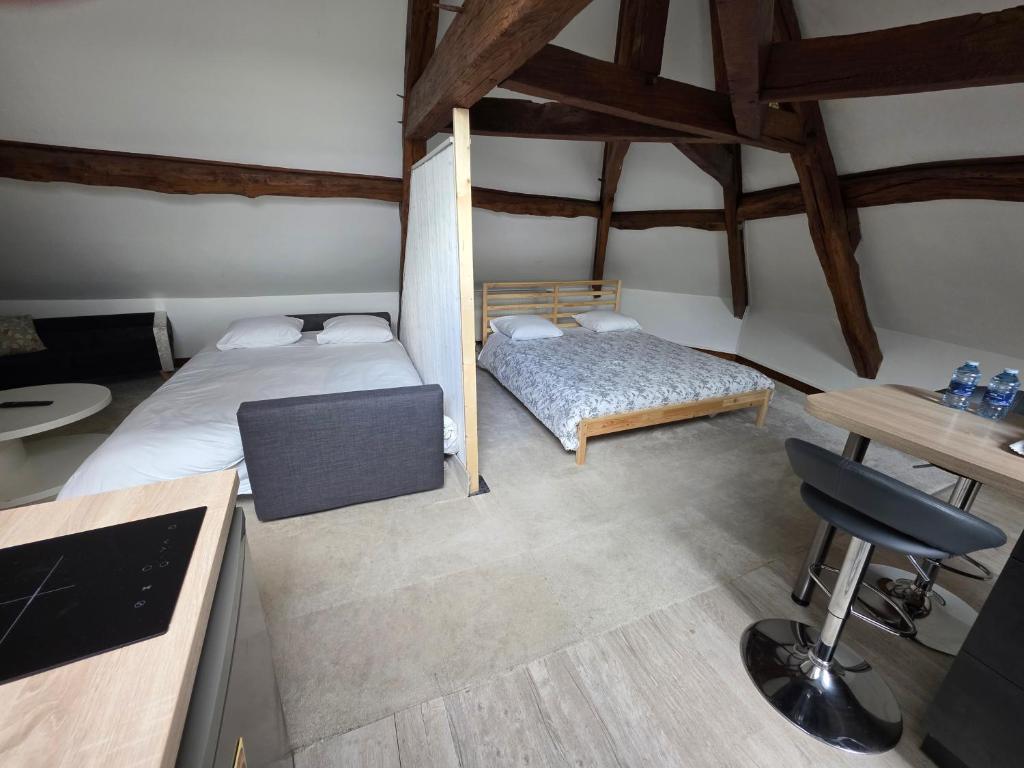 a small room with two beds and a desk at relais st laurent in Chevreuse