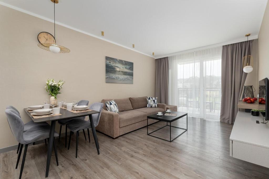 a living room with a couch and a table at BelMare Aqua Resort by Solarento in Międzyzdroje