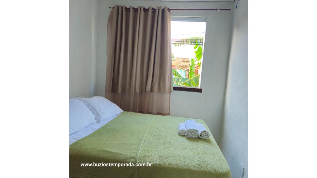 a bedroom with a bed with two towels on it at Pé na areia Geriba Buzios 2 in Búzios