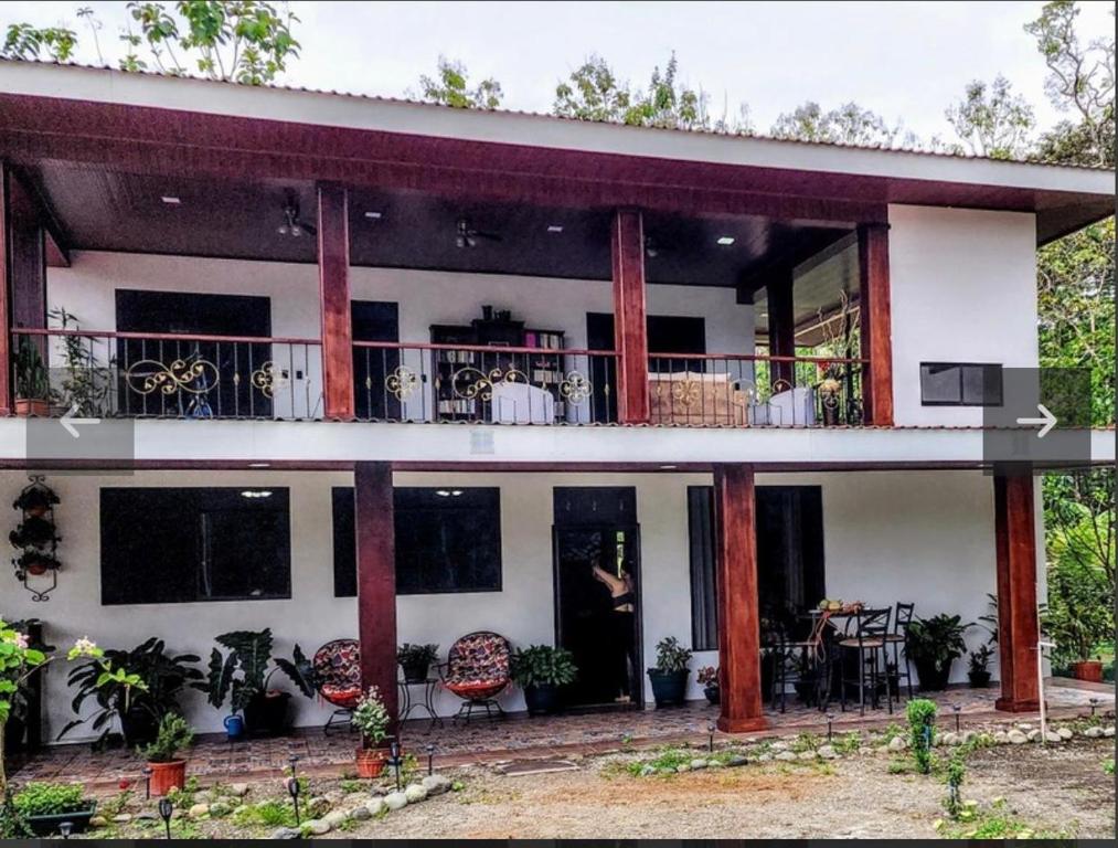 a house with a balcony with tables and chairs at Paseo de Damitas in Quepos