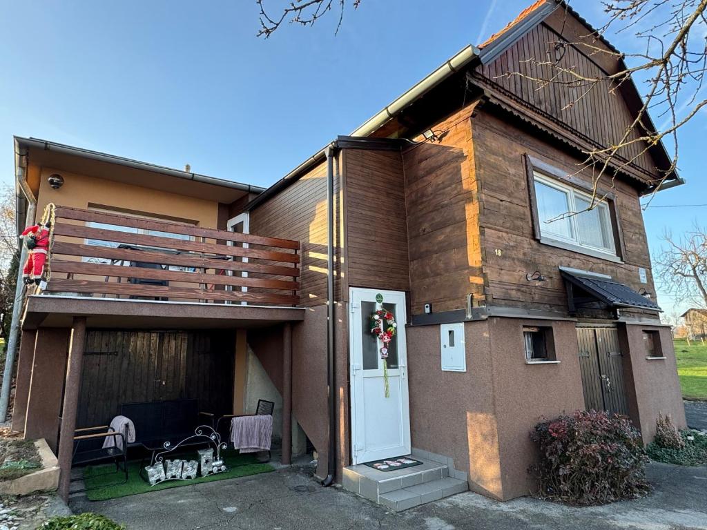 ein Haus mit einem Vordereingang und einer Terrasse in der Unterkunft Apartman Sweet stay by Deda Ferda in Draganići