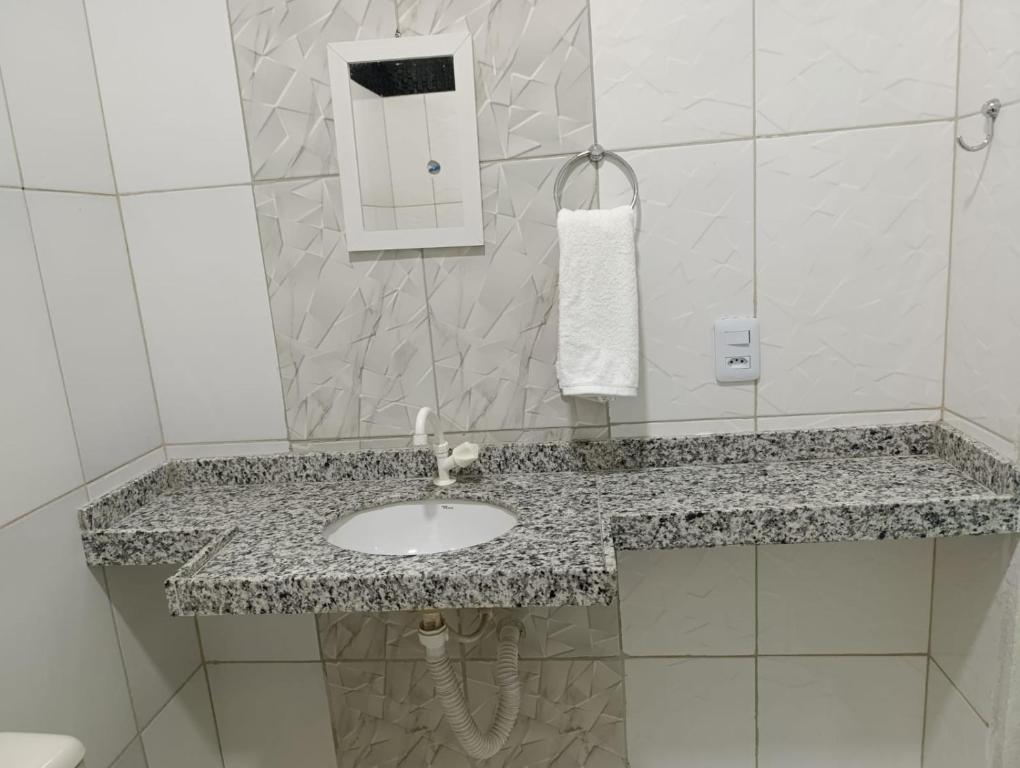 a bathroom with a sink and a mirror at Pousada Cajueiro in Juazeiro do Norte