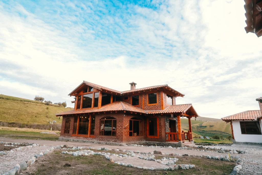 a wooden house in the middle of a field at Taytapak Wasi in Riobamba
