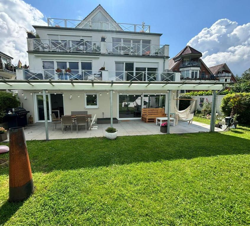 a large white house with a large patio at Family Beach Appartement Laboe in Laboe
