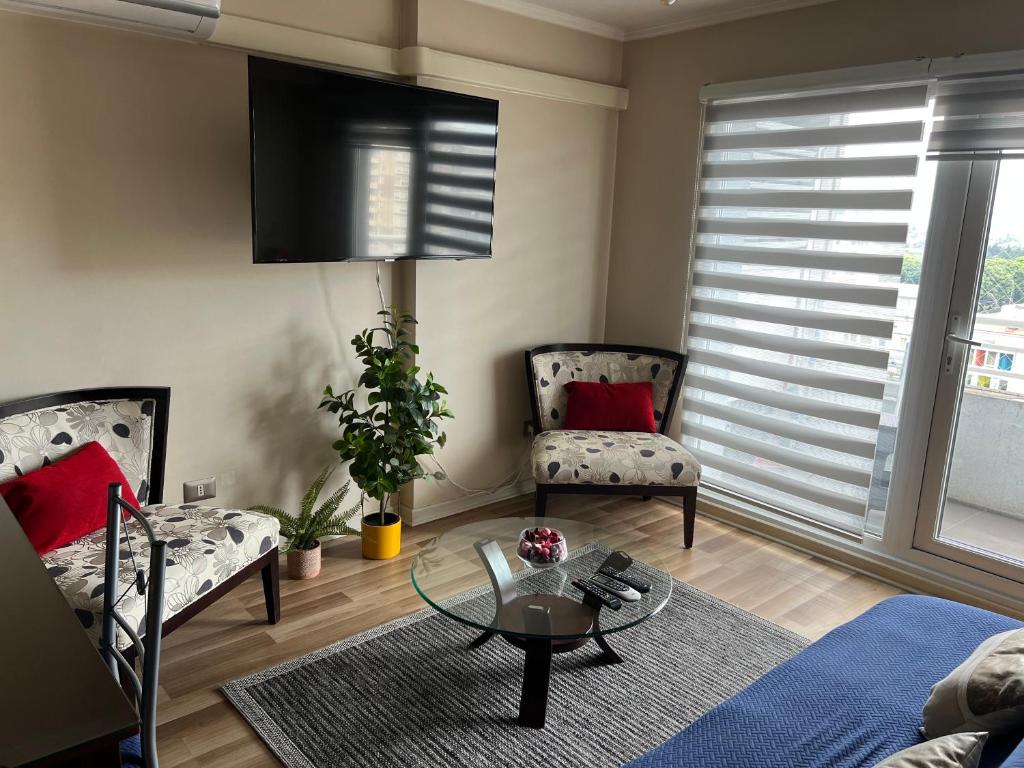 un soggiorno con due sedie e un tavolo di Departamento en Centro de Temuco a Temuco