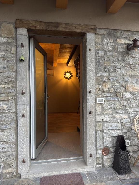 an open door into a room with a stone wall at Naš duam in Stregna