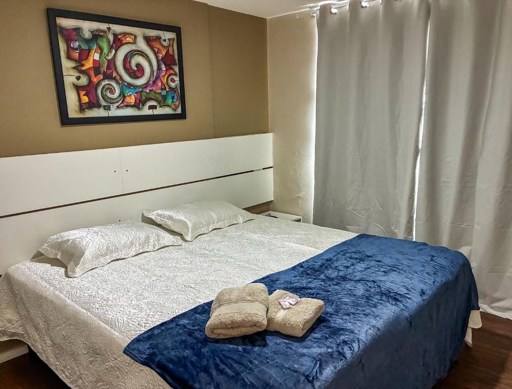 una camera da letto con un letto con due asciugamani sopra di Flat no Centro de Campo Grande a Campo Grande