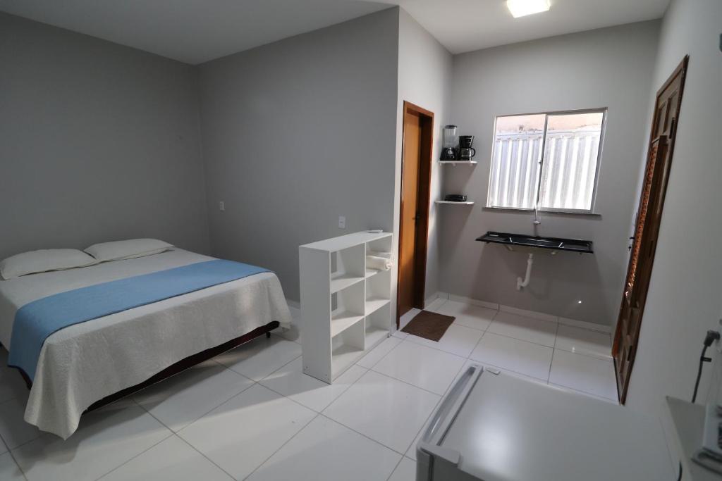 een witte slaapkamer met een bed en een raam bij Casa-Quarto Parnaíba in Parnaíba