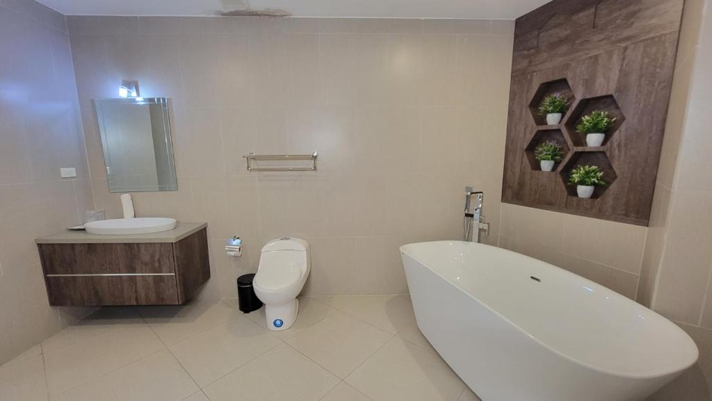 a bathroom with a tub and a toilet and a sink at Navio Hotel in Manta