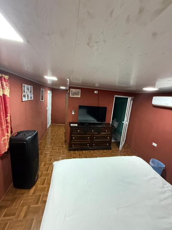 Un dormitorio con una cama y un televisor de pantalla plana. en Caribou, en Monterrico
