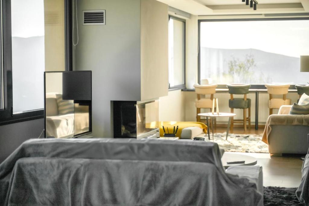 a living room with a couch and a fireplace at Elysian Villa by Ski Alure in Arachova