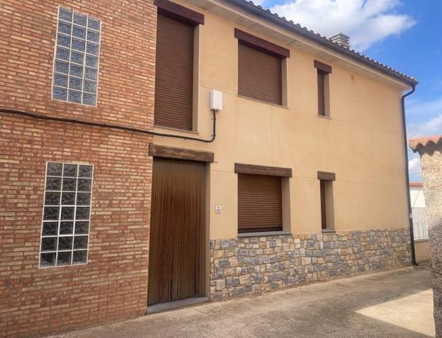 un edificio in mattoni con una porta e un muro di mattoni di La Paidera de Cutanda 