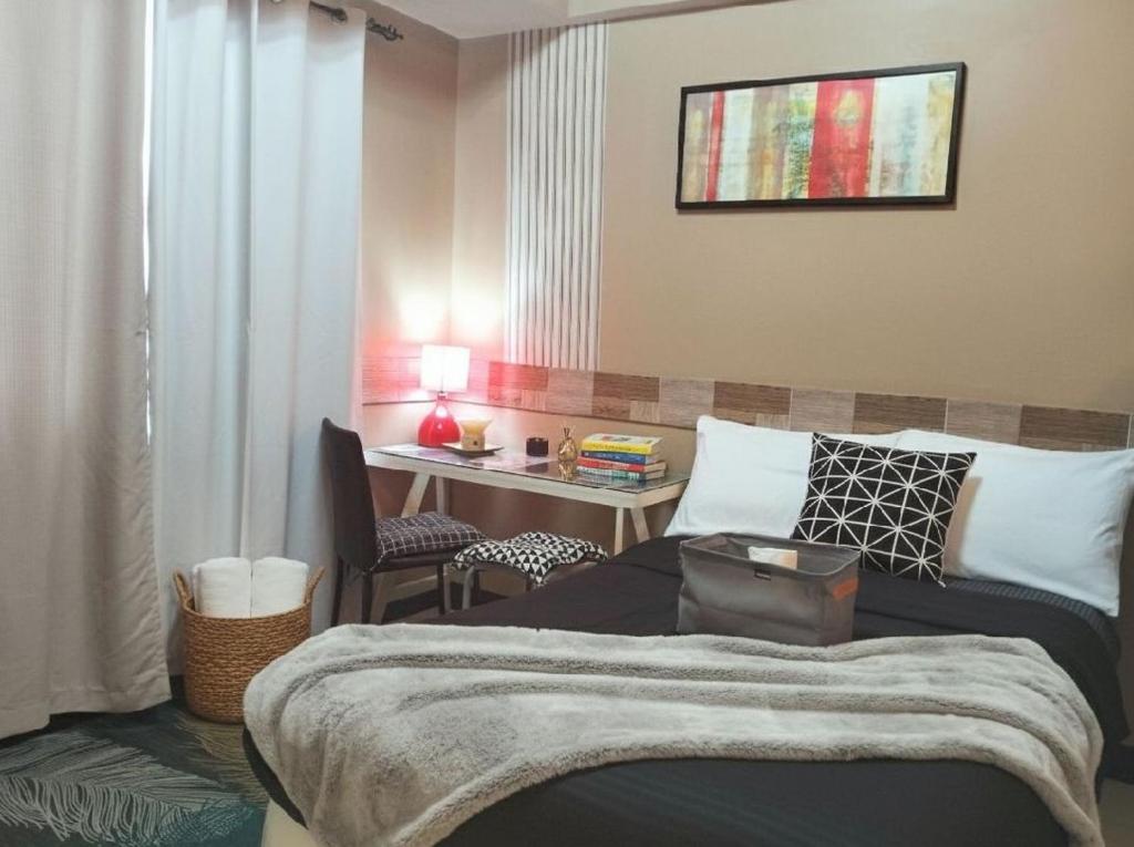 a bedroom with a bed and a desk and a table at BGC Mckinley City Center Apartments - Global City in Manila