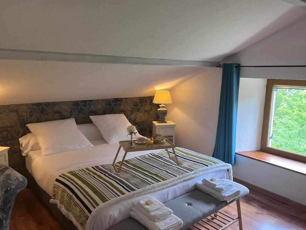 L'Ermitage of Meyriat في Brénod: غرفة نوم بسرير كبير ونافذة