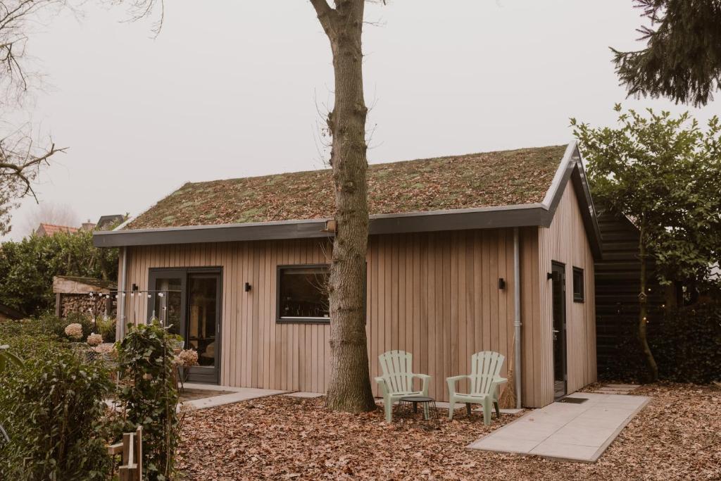 una piccola tettoia con due sedie e un albero di De Eikenloft a Heerenveen