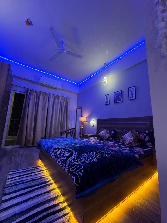 a bedroom with a bed and a ceiling fan at Crown Suites in Greater Noida