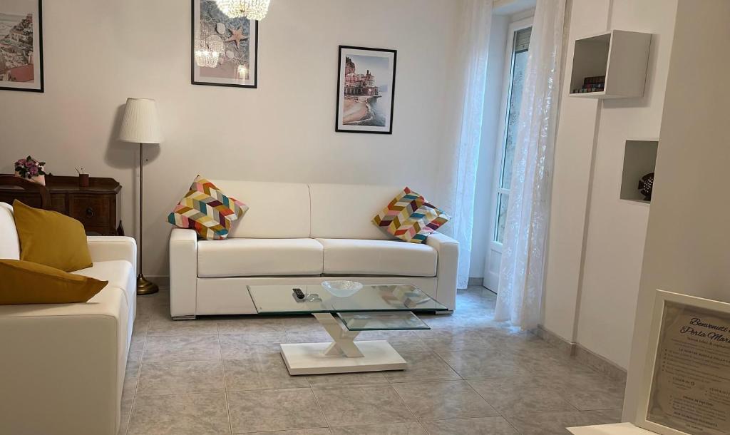 a living room with a white couch and a table at Perla Marina - Salerno in Salerno