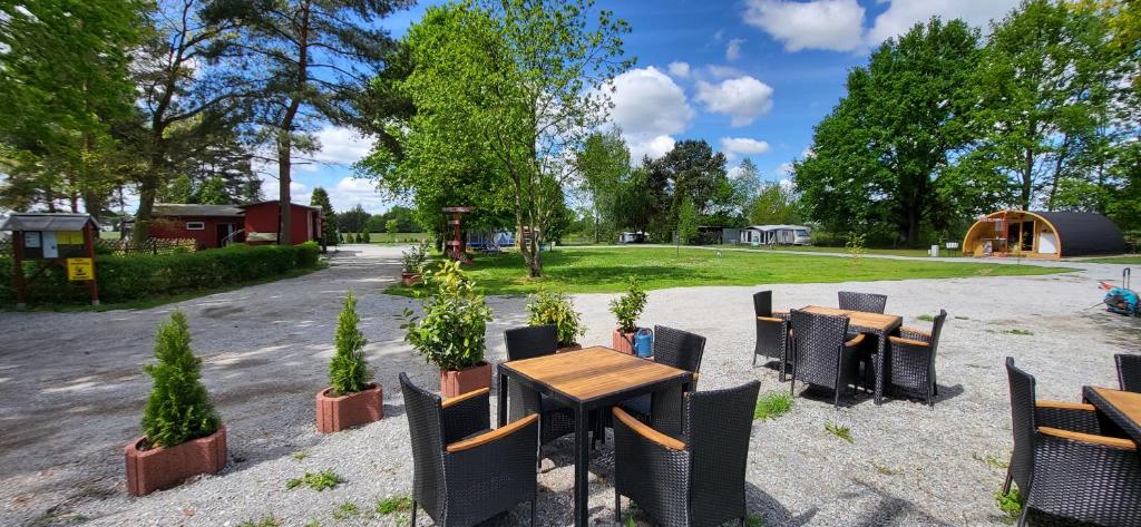 un groupe de tables et de chaises dans un parc dans l'établissement Wanderhütte Woody, à Schwarzbach