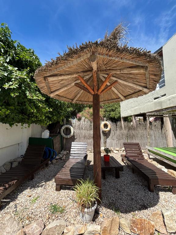 Costa Clara Hotel في سانتا كلارا ديل مار: فناء مع مقاعد ومظلة كبيرة