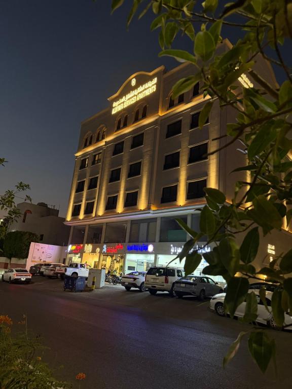 a large building with cars parked in front of it at الضيافة المثالية للشقق المخدومة Aldiyafa Serviced Apartments in Jeddah