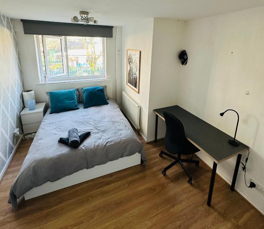 The Oasis Room - Fast Wi-Fi - Private Workspace في مانشستر: غرفة نوم مع سرير مع مكتب وسرير سيد