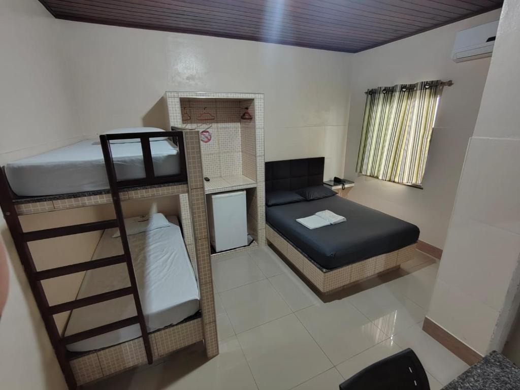 a small room with a bunk bed and a desk at Hotel Val-de-Cans Aeroporto in Belém