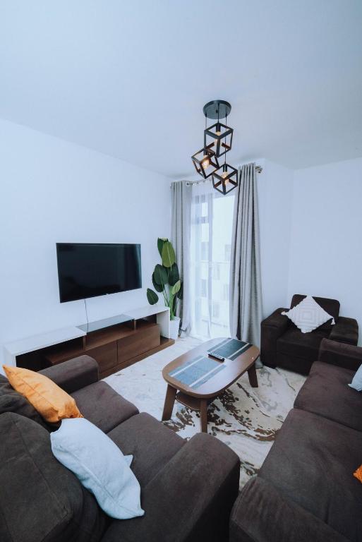 a living room with a couch and a tv at Shan's Comfort Sanctuary in Tatu City