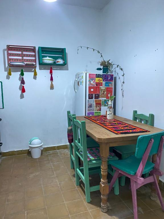 een keuken met een tafel, stoelen en een koelkast bij casa corazOm in Mar de Ajó