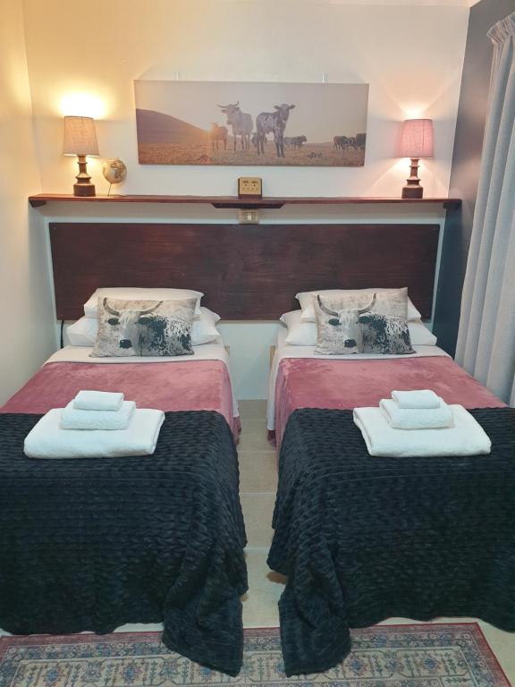 a hotel room with two beds and two lamps at Hibiscus B&B in Strand