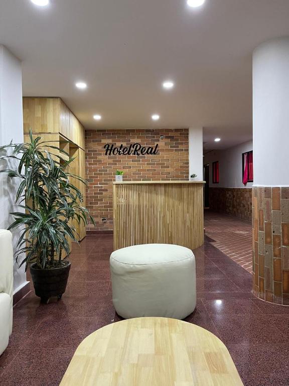a lobby with aoked rent sign on a brick wall at Hotel Real Alejandria in Alejandría