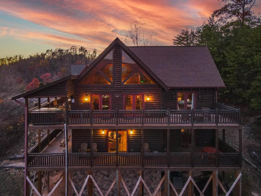 een blokhut met een omlopend terras bij zonsondergang bij Altitude Adjustment in Sevierville