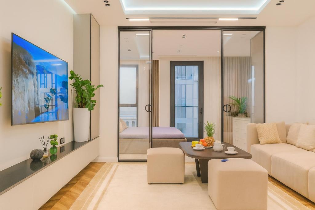 una sala de estar con un sofá y una mesa en Nest One Luxe, Элитные апартаменты с балконом и видом на фонтан Tashkent City Park 110, en Tashkent