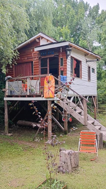 une cabane en rondins avec un porche et une maison dans l'établissement Kailash, à La Porteña