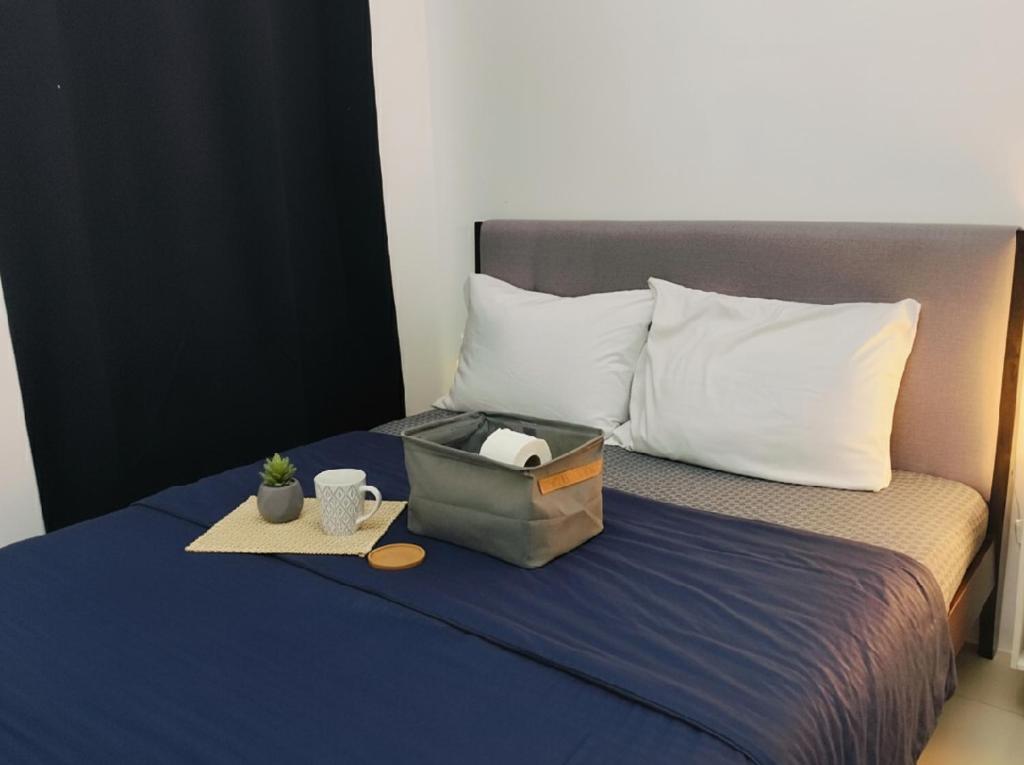 a bed with a blue blanket and a suitcase on it at Makati Business District Prime Accommodations in Manila