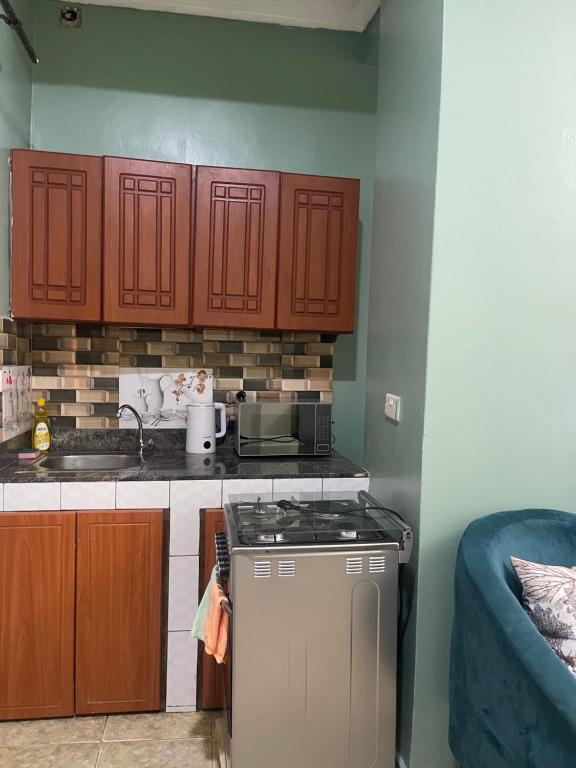 une cuisine avec des armoires en bois et un four à plaques de cuisson dans l'établissement Hella home, à Kampala