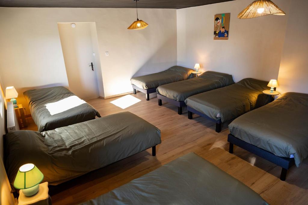 a room with four beds in a room at Les chambres de Marie in Villié-Morgon