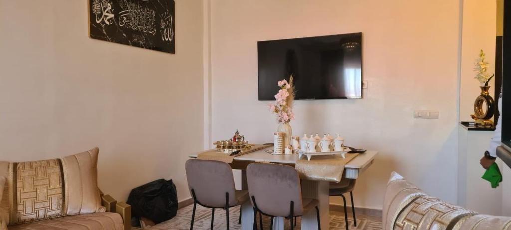 uma sala de estar com uma mesa com cadeiras e um sofá em Appartement Fes em Fez