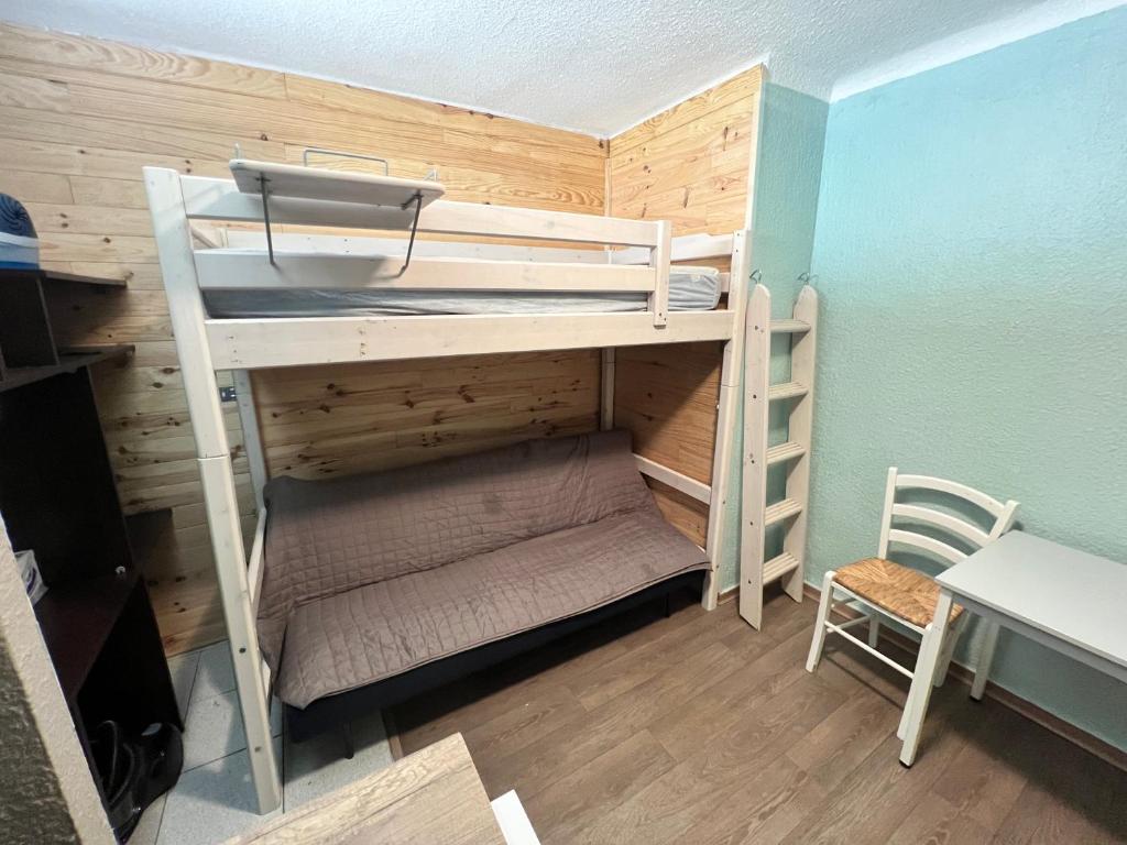 a bunk bed in a room with a desk and a chair at Studio centre-ville in Cluses