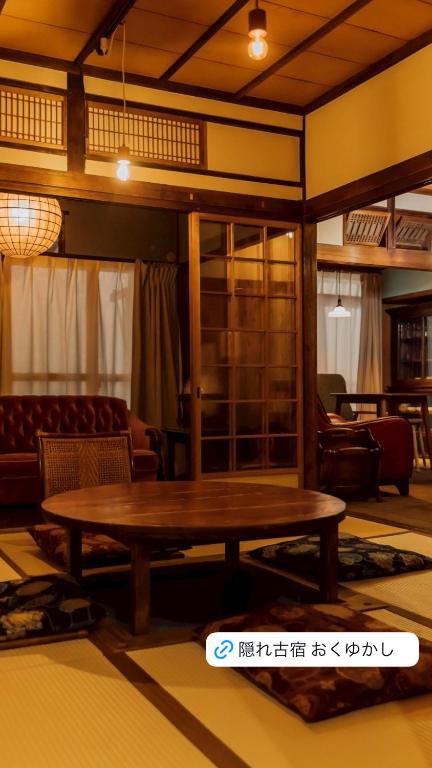 a living room with a wooden table and chairs at 隠れ古宿 おくゆかし in Beppu
