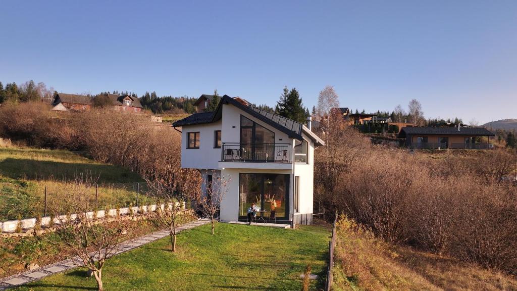 a white house with a balcony on a hill at Dzvin in Slavske