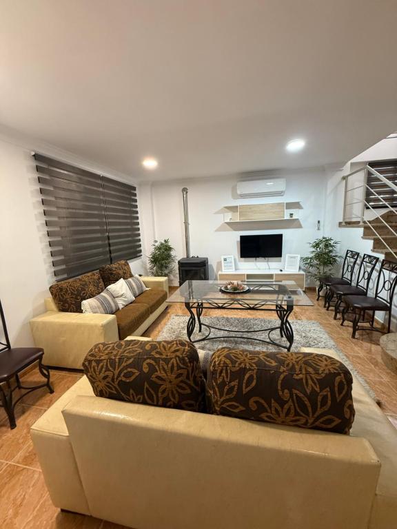 Una sala de estar con sofás y una mesa de café. en ALOJAMIENTO Rural AVD SIERRA MÁGINA, en Carchelejo