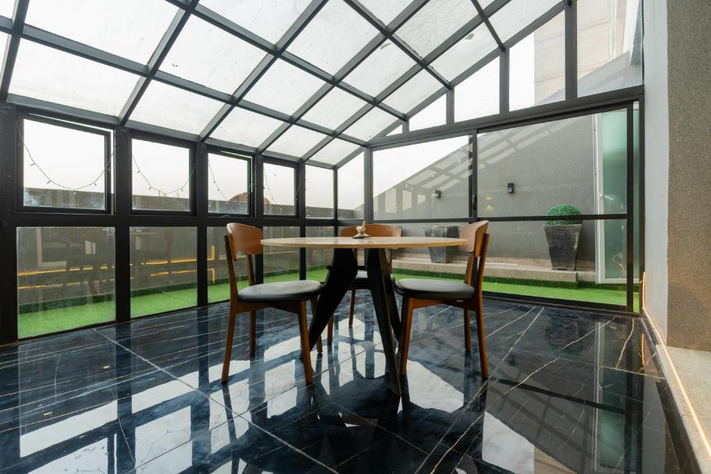 uma mesa e duas cadeiras num quarto com janelas em Gold Crest Signature One Bedroom Family Apartments - City View DHA Lahore em Lahore