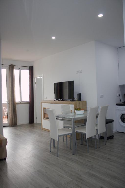 a dining room with a table and white chairs at Apartamento Laranjeiras dois in Palhota