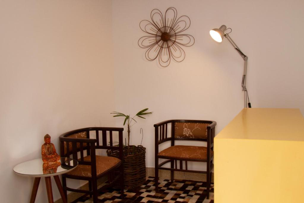 una stanza con due sedie e un tavolo e una lampada di Casinha Vale do Sol a Nova Lima