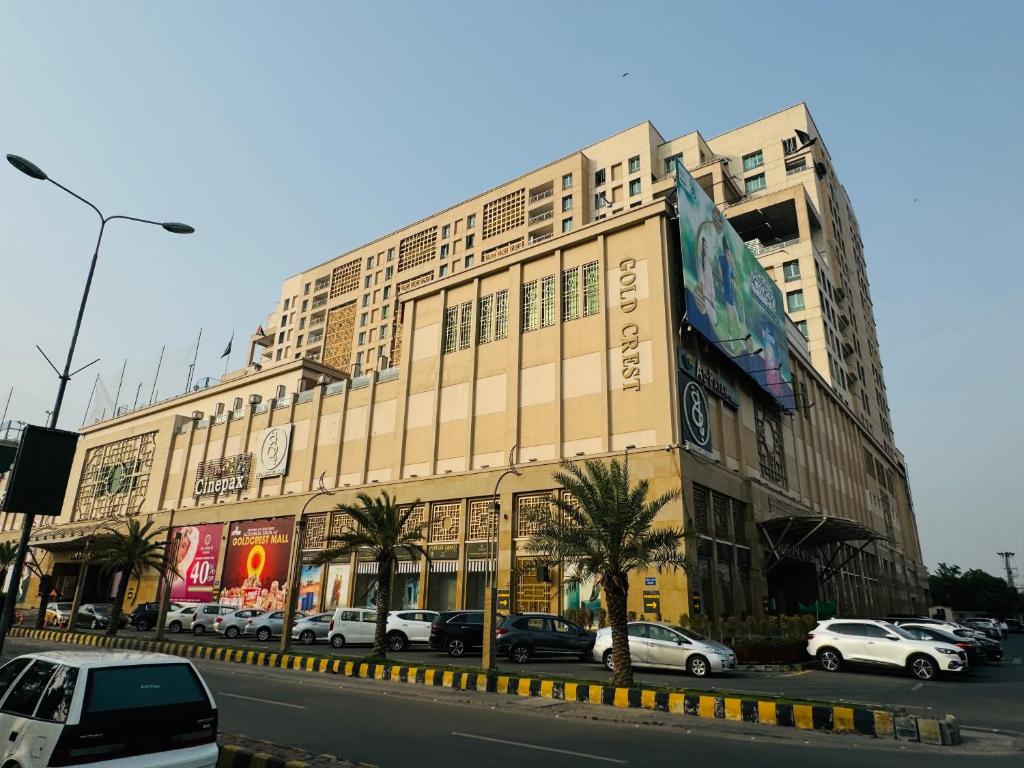un grande edificio con auto parcheggiate di fronte di Gold Crest Signature One Bedroom Family Apartments - City View DHA Lahore a Lahore