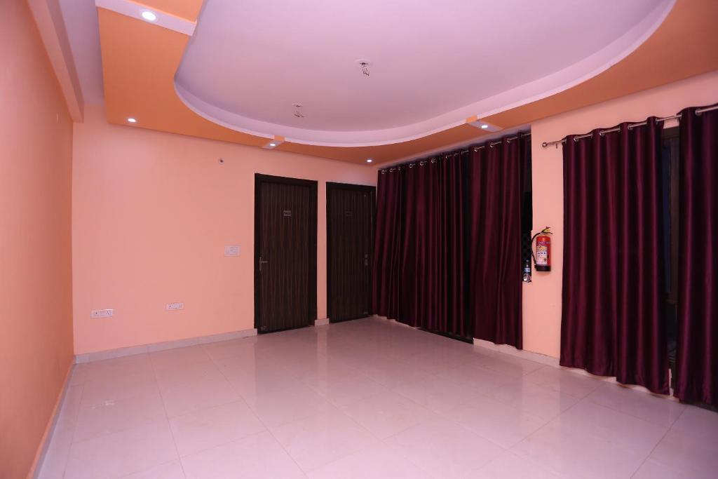 Hotel O Golden Palace في غازي آباد: غرفة فارغة بأبواب سوداء وستائر حمراء