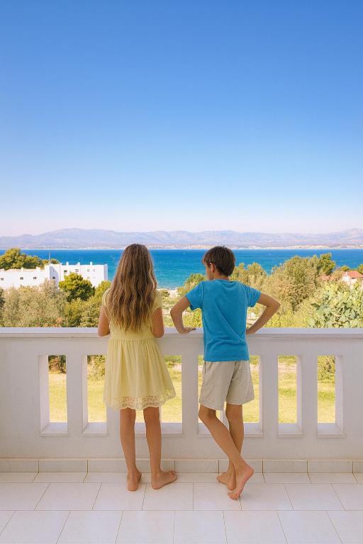 two children standing on a fence looking out at the ocean at Caecilia & Lawrence Organic Mediterranean Sea Villa in Chalkida