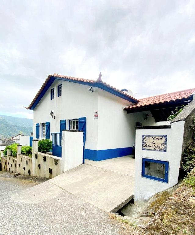 una casa blanca con adornos azules en Casa da Belavista, en Furnas