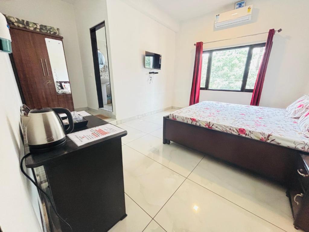 1 dormitorio con 1 cama y teléfono en una habitación en Aroha home stay, en Pālampur